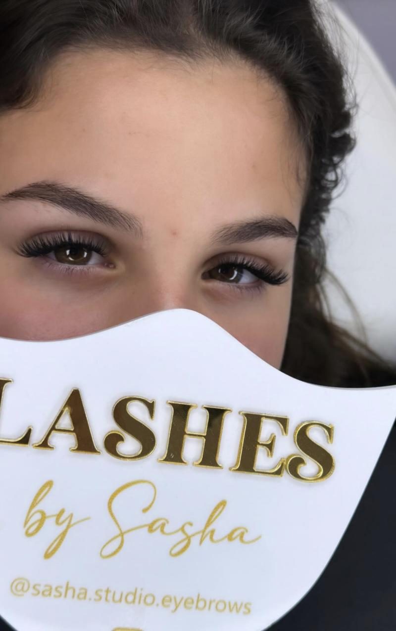 Cliente tenant le panneau Lashes by Sasha