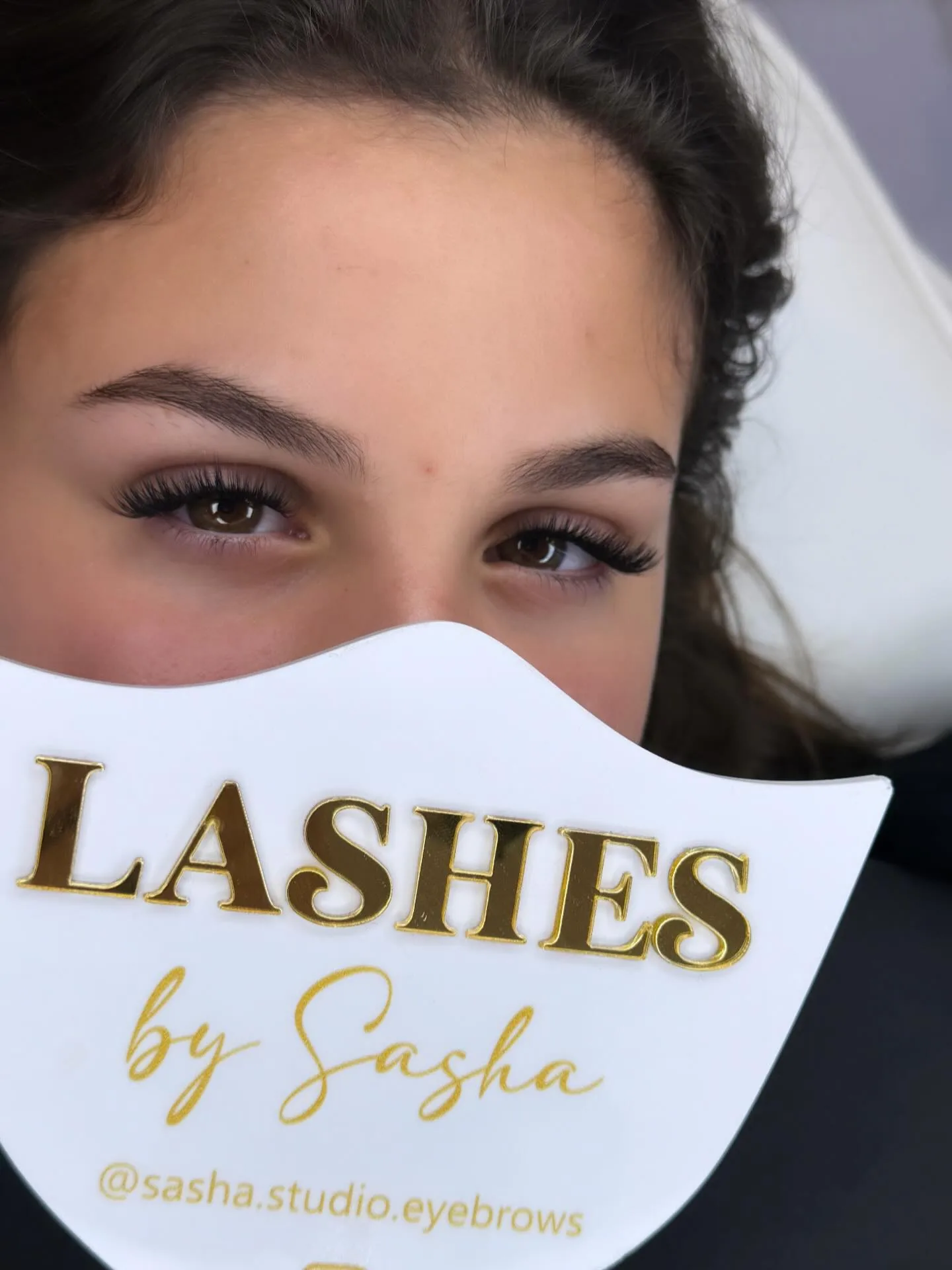 Cliente derrière la plaque dorée LASHES by Sasha