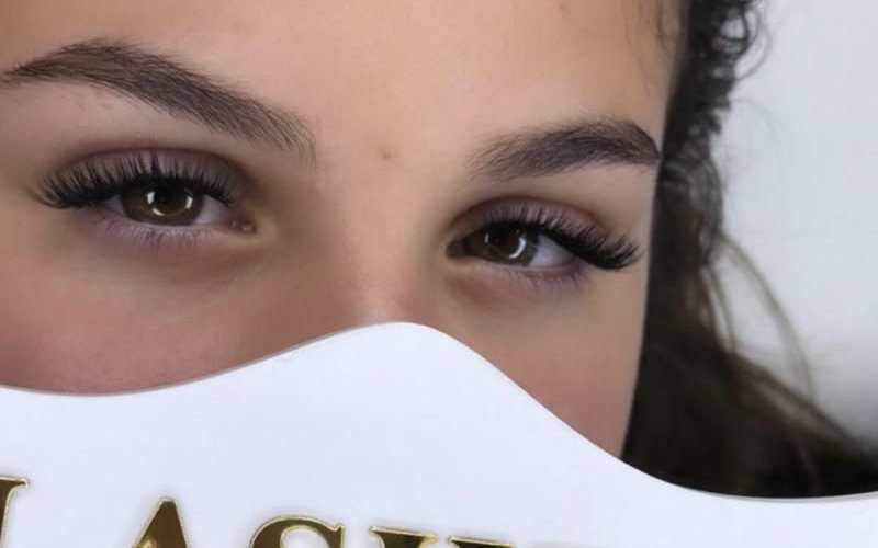 Cliente derrière le panneau doré Lashes by Sasha